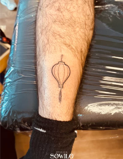 Tatouage lanterne chinoise sur le mollet réalisé par Atelier Sowilo à Clisson