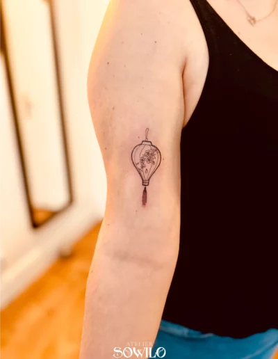 Tatouage lanterne chinoise bras femme réalisé par Atelier Sowilo à Clisson