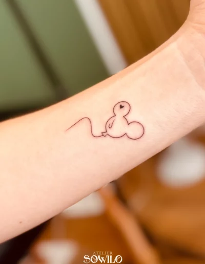 Tatouage réaliser par l'Atelier Sowilo sur l'avant bras d'une femme. Il représente un ballon gonflable en forme de tête de Mickey