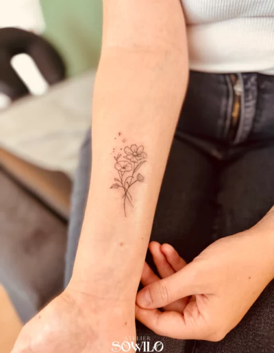 Tatouage avant bras, femme , représentant un bouquet de fleurs fait par l'Atelier Sowilo