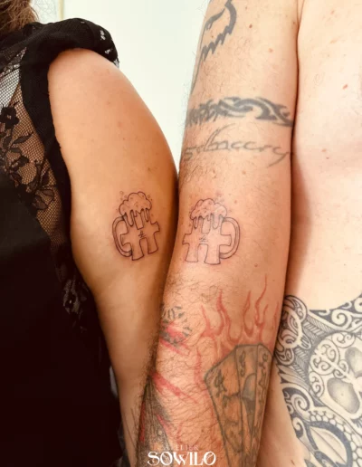 Tatouage couple homme et femme, avant bras représentant le logo Hellfest avec mousse à bière type choppe fait par l'Atelier Sowilo