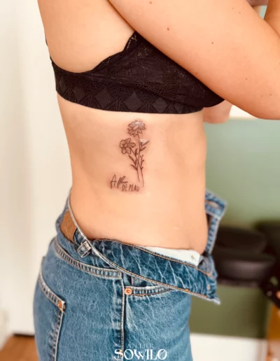 Tatouage buste, femme , représentant un bouquet de fleurs avec un lettrage a fleur de peau fait par l'Atelier Sowilo