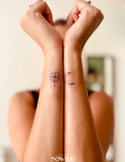 Tatouage avant bras, femme , type minimaliste représentant un trèfle et une demi lune, trait fin noir fait par l'Atelier Sowilo